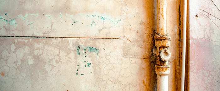 rusty pipe on distressed wall