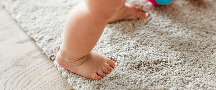 baby feet on carpet and wood flooring