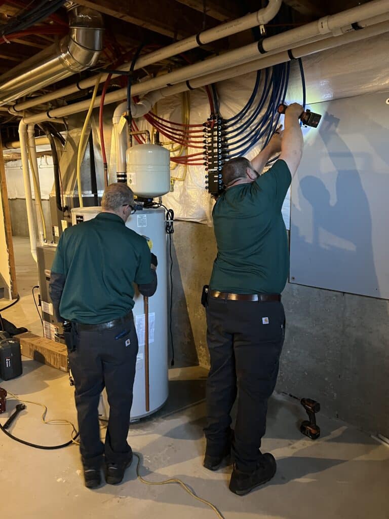 Two Schuler Service technicians work on installing a water heater.